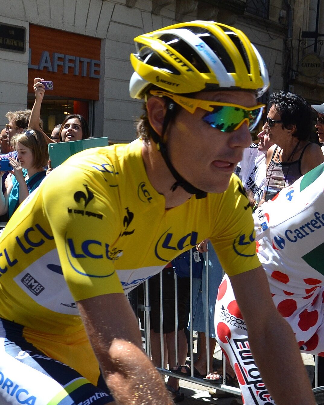Daryl Impey in the yellow jersey on his bike, in front of the crowd