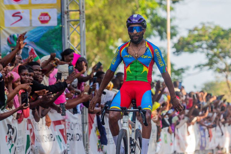 An Eritrean rider raises his arms at the finish, in front of the crowd