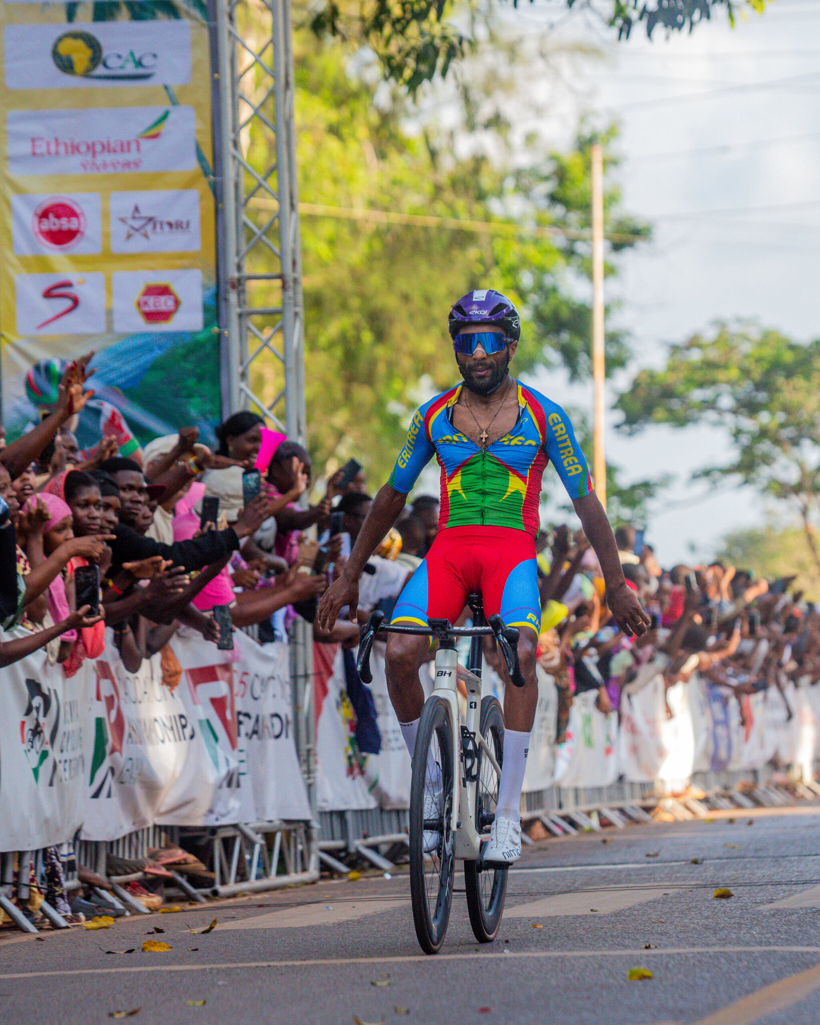 Un coureur érythréen lève les bras à l'arrivée, devant la foule