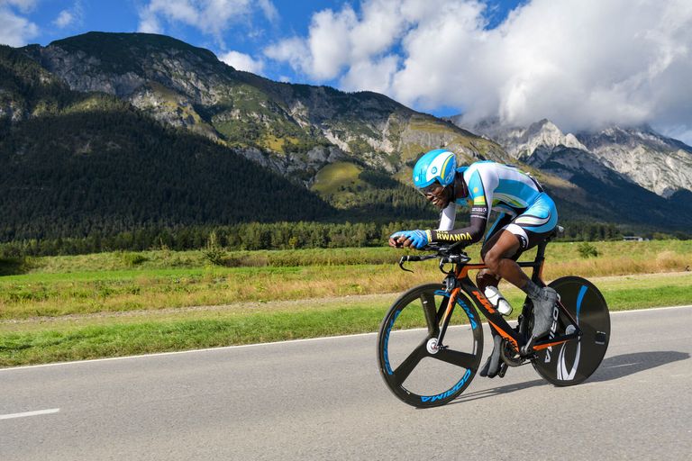 Joseph Areruya sur son vélo de contre-la-montre, des montagnes en arrière-plan