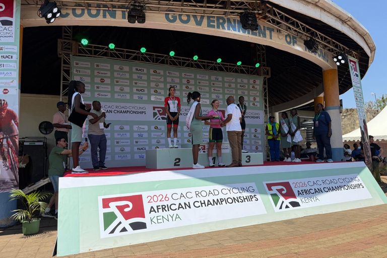 An official presents the winner with her medal on the top step of the 2026 African Road Championships podium in Kisumu, between the second and the third