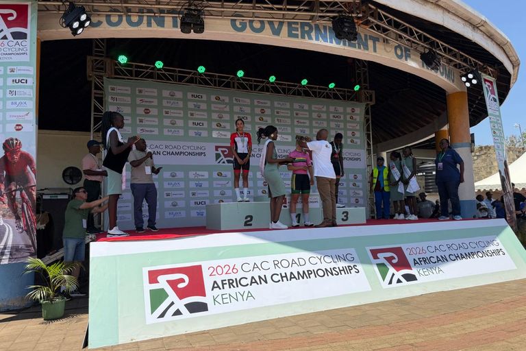 An official puts the medal around the neck of the junior women's road race winner, on the podium of the 2026 African Road Championships in Kisumu