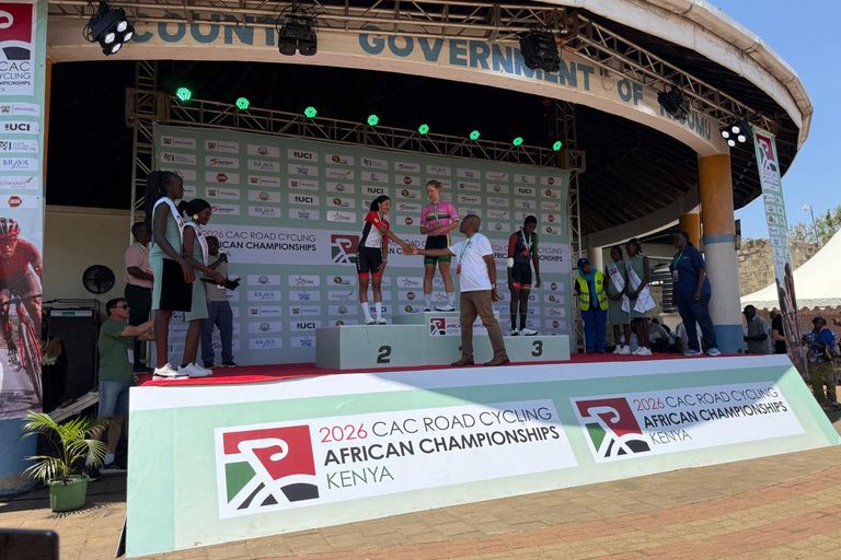 The first three of the junior women's road race on the podium of the 2026 African Road Championships in Kisumu; an official shakes hands with the runner-up
