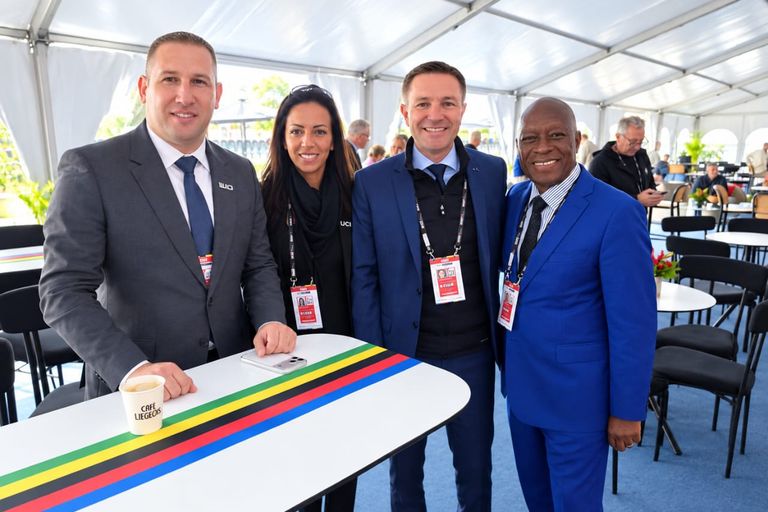 Le président de la CAC avec trois personnes, autour d'une table aux bandes arc-en-ciel