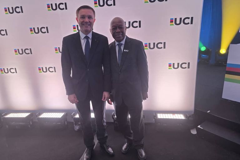 Le président de la CAC et une autre personne, devant un mur aux logos de l'UCI