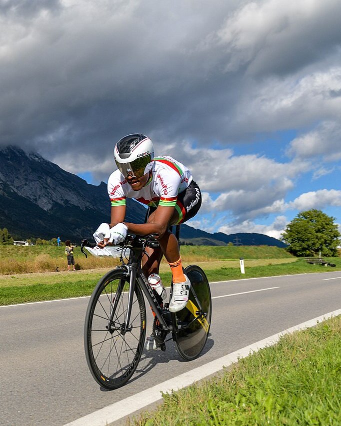 Paul Daumont sur son vélo de contre-la-montre, des montagnes en arrière-plan
