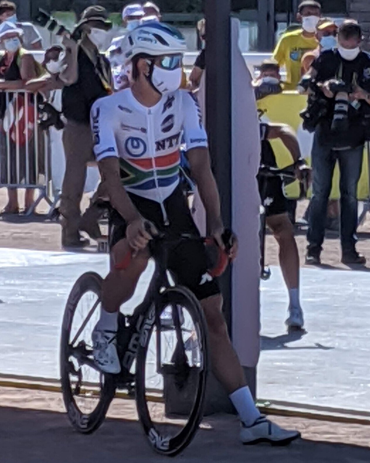 Ryan Gibbons sur son vélo, casque blanc, avant le départ d'une étape
