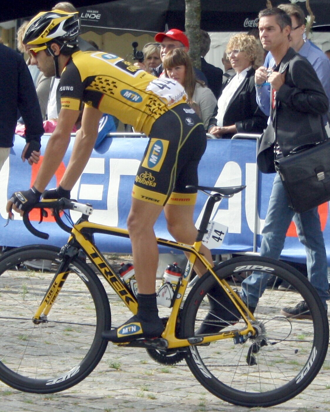 Youcef Reguigui sur son vélo, en maillot jaune et noir, devant le public